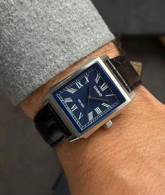 Montre vintage Casio rectangulaire portée au poignet, mettant en valeur son boîtier en acier argenté et son bracelet en cuir noir.