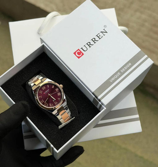 Montre de luxe Curren pour femme avec bracelet bicolore argent et or rose, cadran bordeaux et détails dorés présentée par AuraRichStore Abidjan.