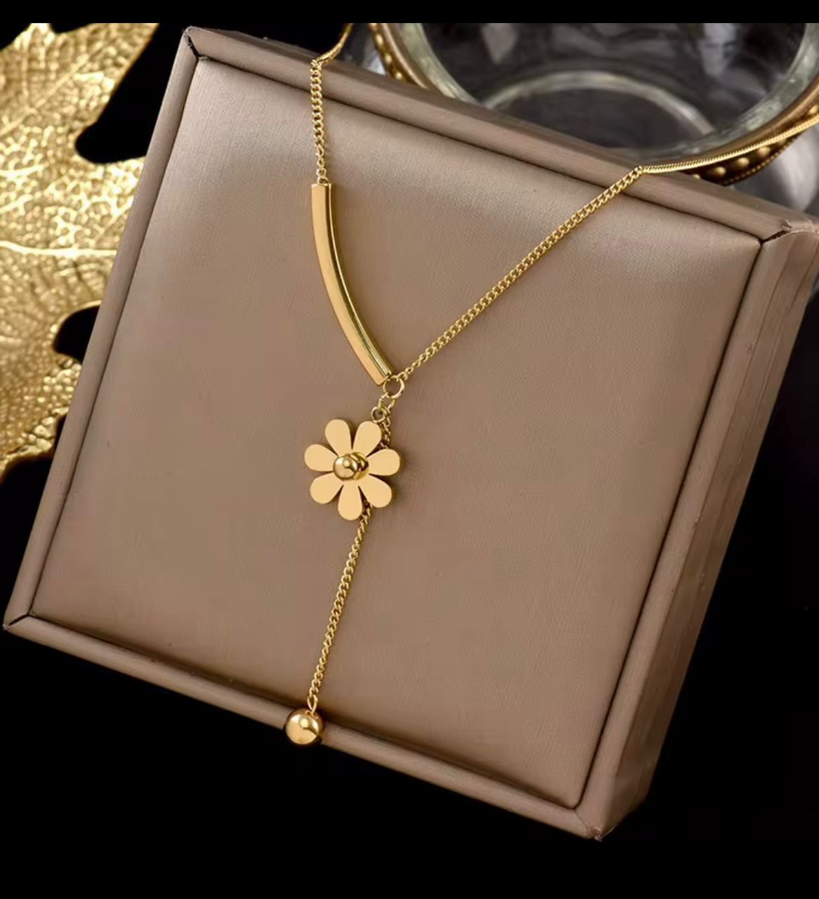Collier doré avec pendentif fleur marguerite porté au cou - Bijoux de luxe Aura Rich Store Abidjan
