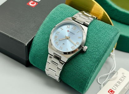 Montre Curren pour femme avec cadran bleu ciel, chiffres romains dorés, bracelet en acier inoxydable bicolore argent et or, présentée avec son écrin blanc